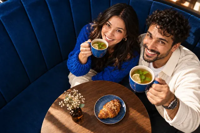 AI-created illustrative photo of two fictional adults at a cafe for Adventist Talo.