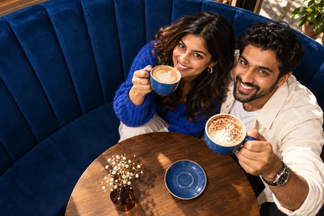 AI-created illustrative photo of two fictional adults at a cafe for Gujarati Talo.