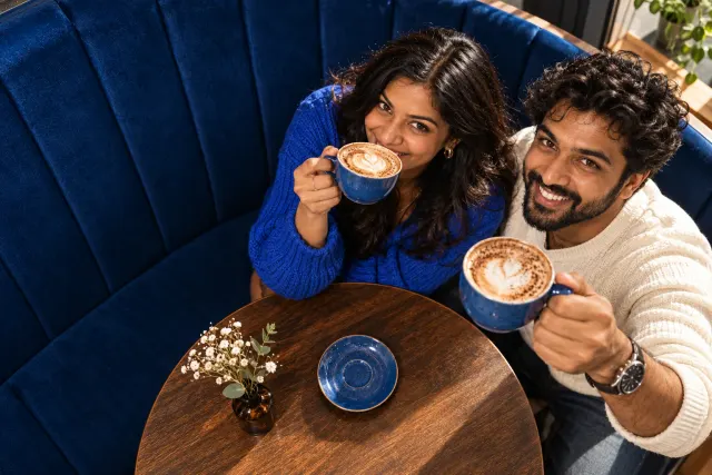 AI-created illustrative photo of two fictional adults at a cafe for Malayali Talo.