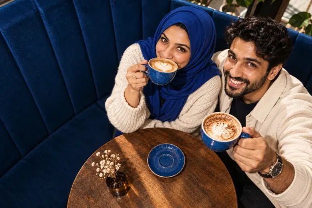 AI-created illustrative photo of two fictional adults at a cafe for Shia Muslim Talo.