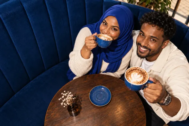 AI-created illustrative photo of two fictional adults at a cafe for Somali Talo.