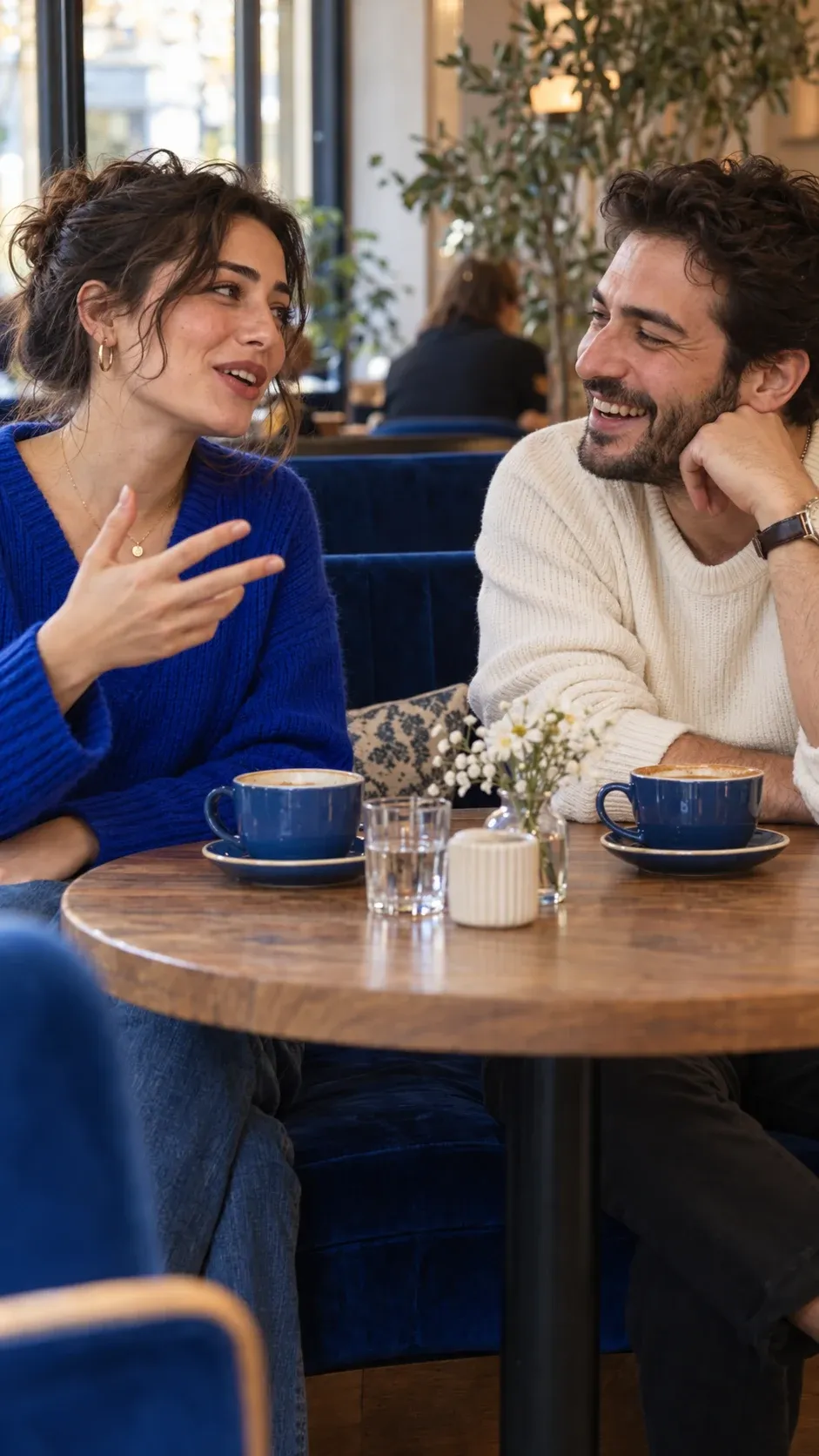 Two adults talking over coffee at a cafe.